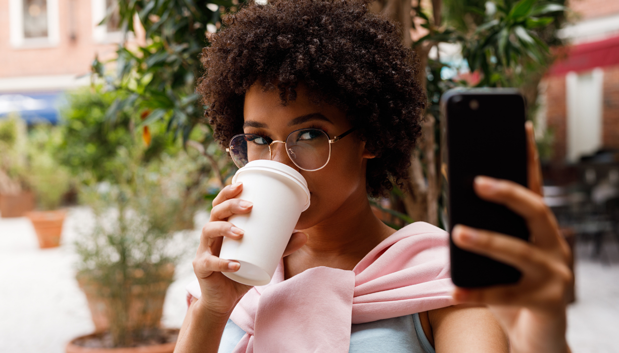 Influencer girl drinks coffee while posting on social media